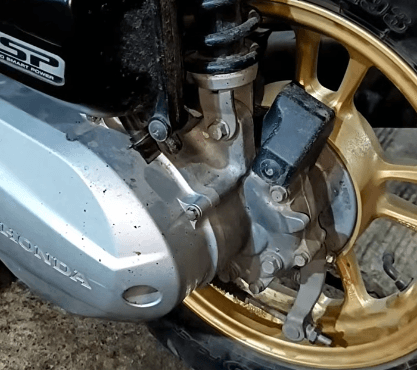 The rear wheel is producing a rough grinding noise while driving, especially at low speeds and during acceleration